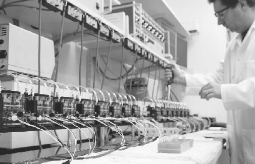 Image of Ussing Chamber Systems connected together. In this image is multiple eight channel ussing chamber systems with a laboratory technician administering drug to each side of the ussing chamber.